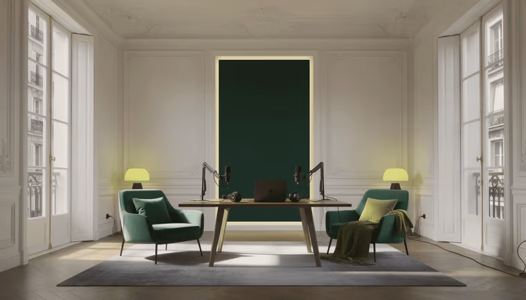 Salon haussmannien aménagé en plateau : deux fauteuils verts face à une table équipée de deux micros